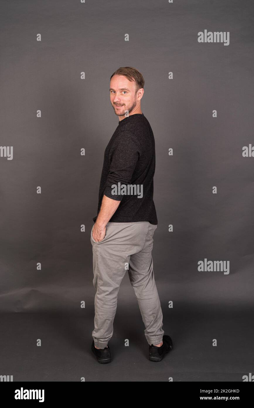 Studio-Porträt des blonden kaukasischen Mannes mit grauem Hemd Stockfoto