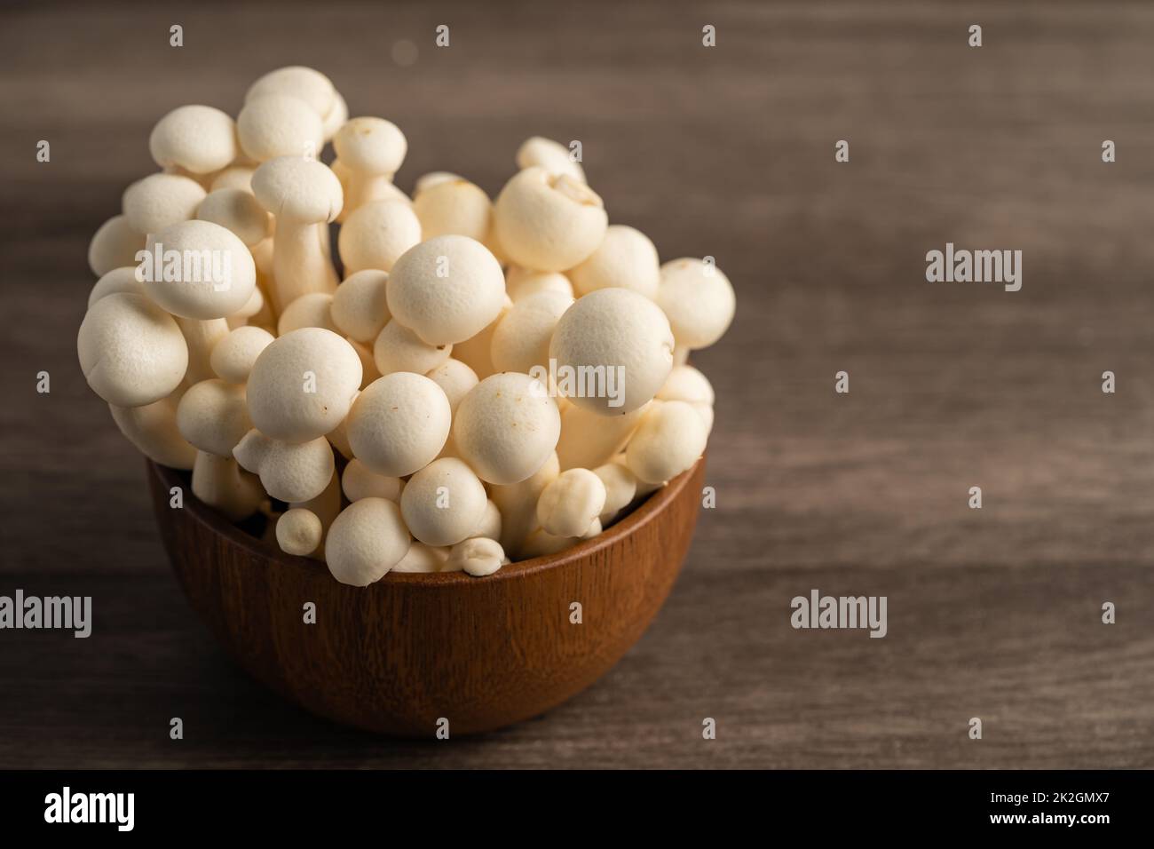 Shimeji, frische weiße Bunapi-Pilze aus Asien in einer Holzschale. Stockfoto