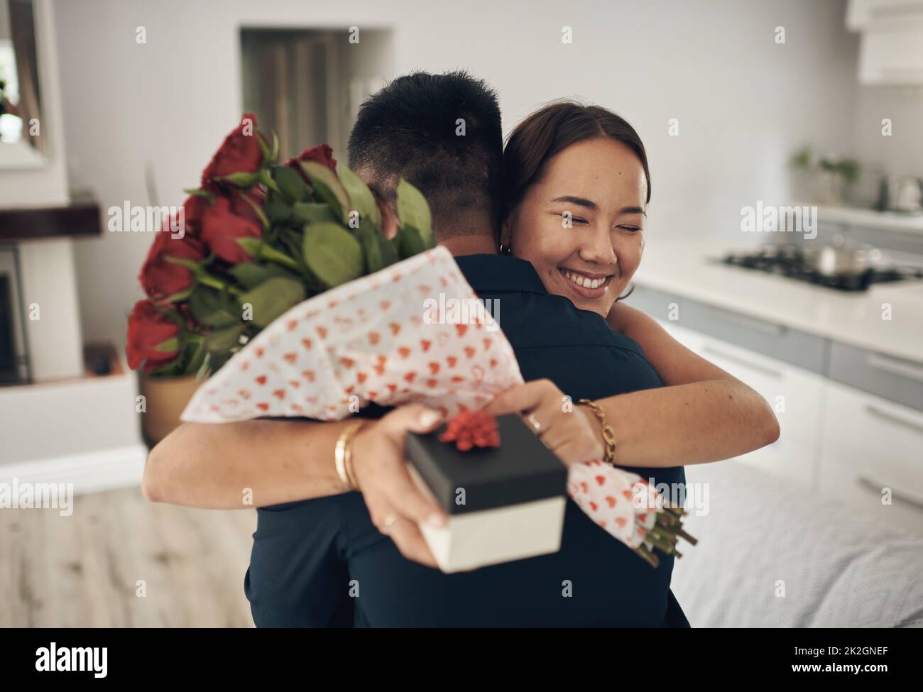 Zufällige Handlungen der Freundlichkeit. Aufnahme eines jungen Mannes, der seine Frau zu Hause mit Blumen überraschte. Stockfoto