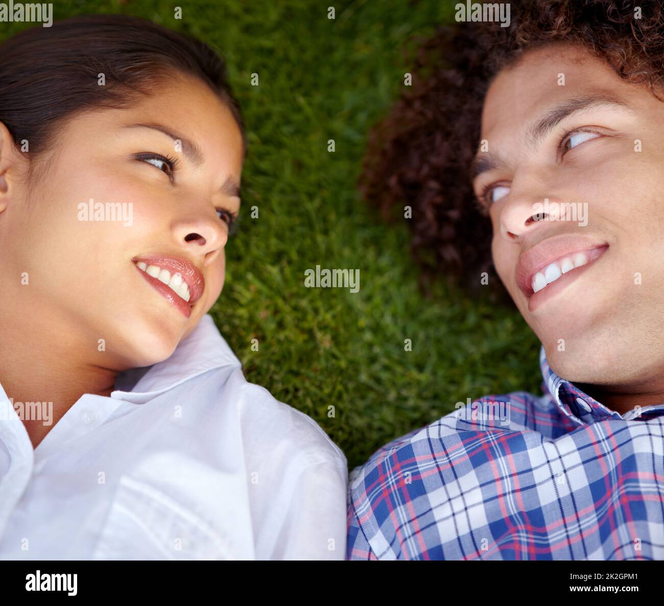 Absolut vertrauensvoll. Aufnahme eines glücklichen jungen Paares, das auf dem Rasen in jeweils otheramp039s Augen blickt. Stockfoto