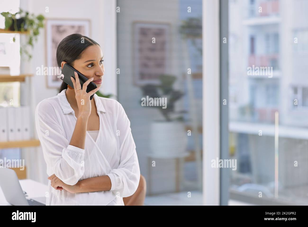 Nie nach Ruhm gerufen, kein Kampf in deinem Namen. Aufnahme einer Geschäftsfrau, die in einem modernen Büro telefoniert. Stockfoto