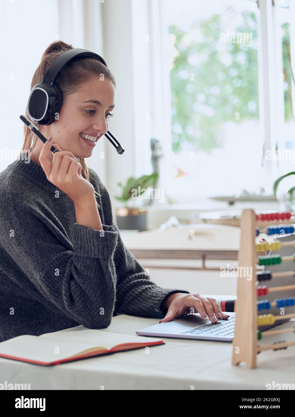 Die Liebe zum Lernen und die Liebe zu Lernenden. Aufnahme einer jungen Frau, die zu Hause mit ihrem Laptop eine Online-Lektion erteilt. Stockfoto