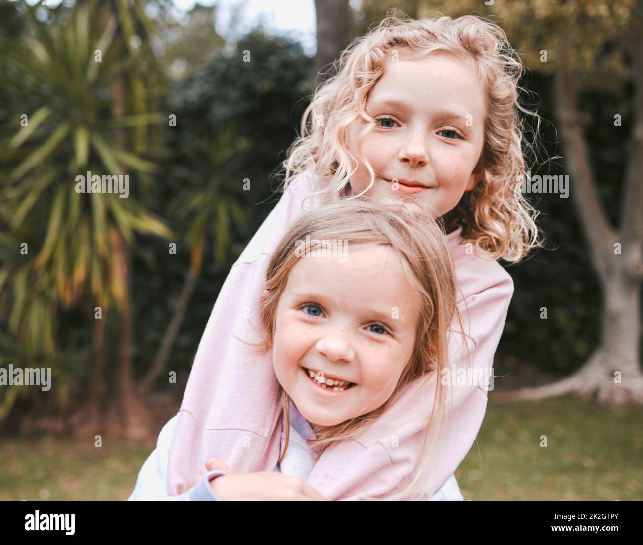 Die Liebe der Schwester ist ein Geschenk von oben. Aufnahme von zwei entzückenden kleinen Mädchen, die Spaß in einem Garten haben. Stockfoto