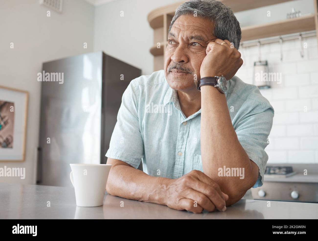 Allein zu sein wird einsam. Aufnahme eines älteren Mannes, der nachdenklich aussass, während er zu Hause Kaffee trank. Stockfoto