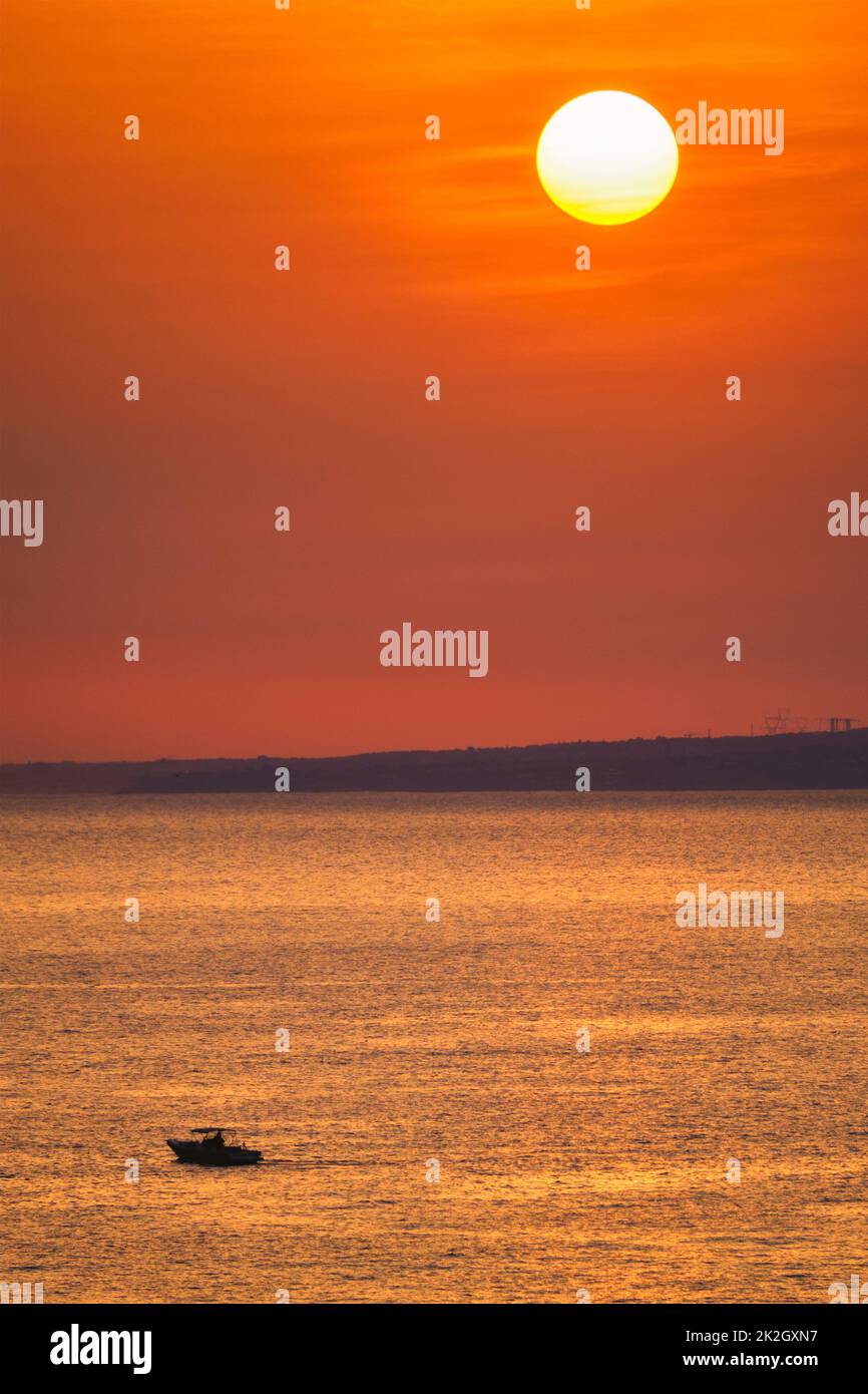 Kleines Fischerboot im Meer bei Sonnenuntergang Stockfoto