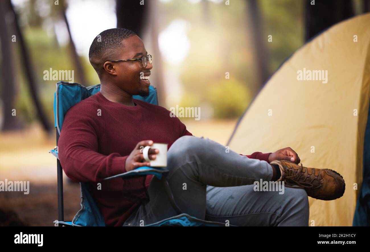Zeit in der Natur zu verbringen ist das Heilmittel für alles. Aufnahme eines Mannes, der Kaffee trinkt, während er draußen auf einem Campingstuhl sitzt. Stockfoto