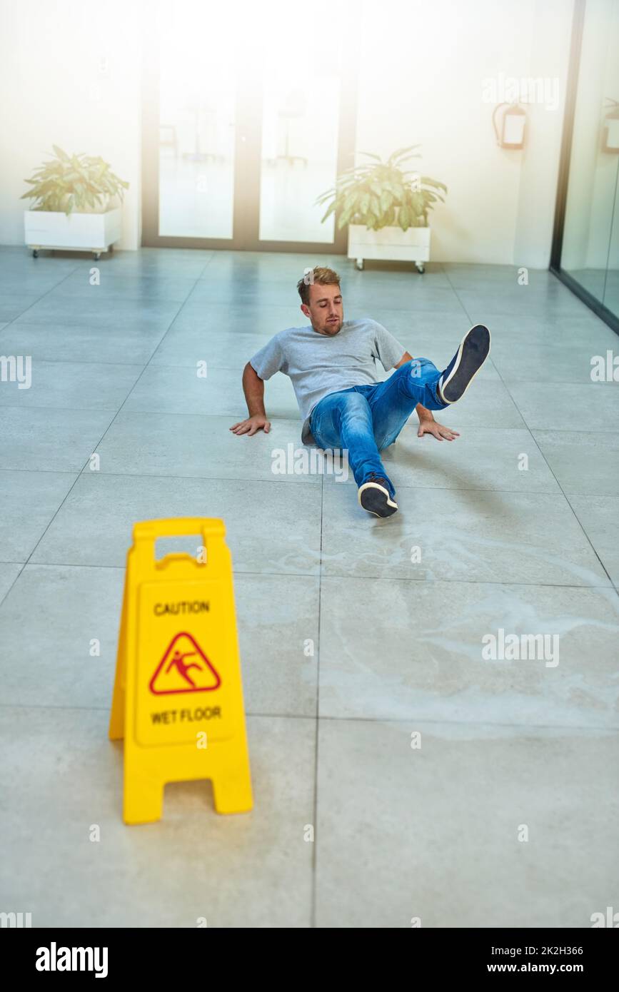Er las das Schild nicht. Aufnahme eines Mannes, der ein Bürogebäude putzt. Stockfoto