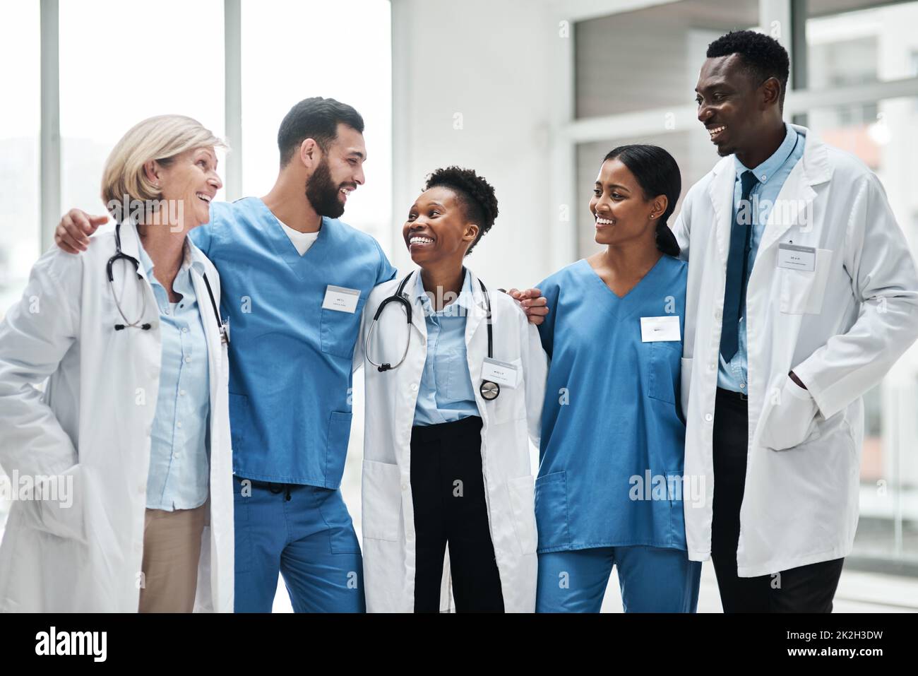 Förderung von Spitzenleistungen im Gesundheitswesen als engagiertes Team. Aufnahme einer Gruppe von Ärzten, die in einem Krankenhaus zusammenstehen. Stockfoto