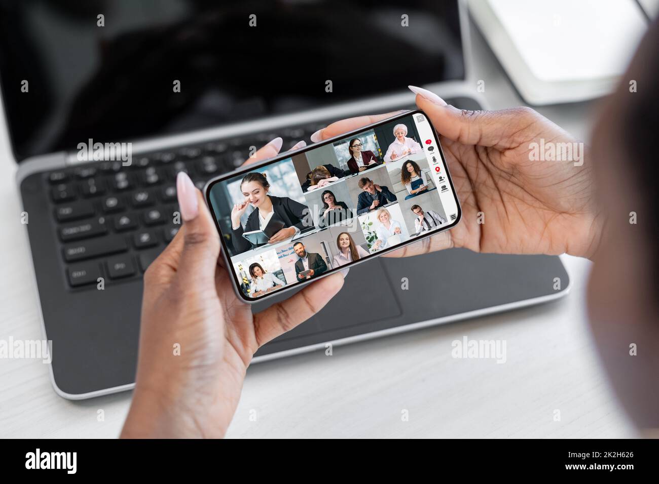 Geschäftliche Telekonferenz. Mobiler Videoanruf. Virtuelles Interview. Kommunikationstechnologie. Frau, die online mit dem Team auf dem Smartphone-Bildschirm zusammenarbeitet. Stockfoto