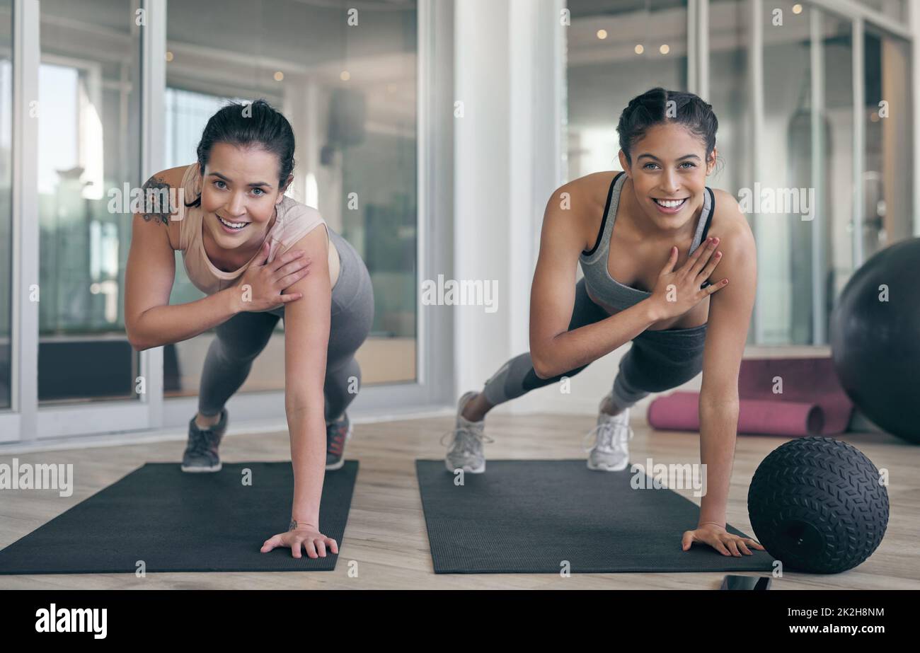 Ein kleiner Fortschritt führt zu großen Ergebnissen. Aufnahme von zwei jungen Athleten, die gemeinsam im Fitnessstudio trainieren. Stockfoto