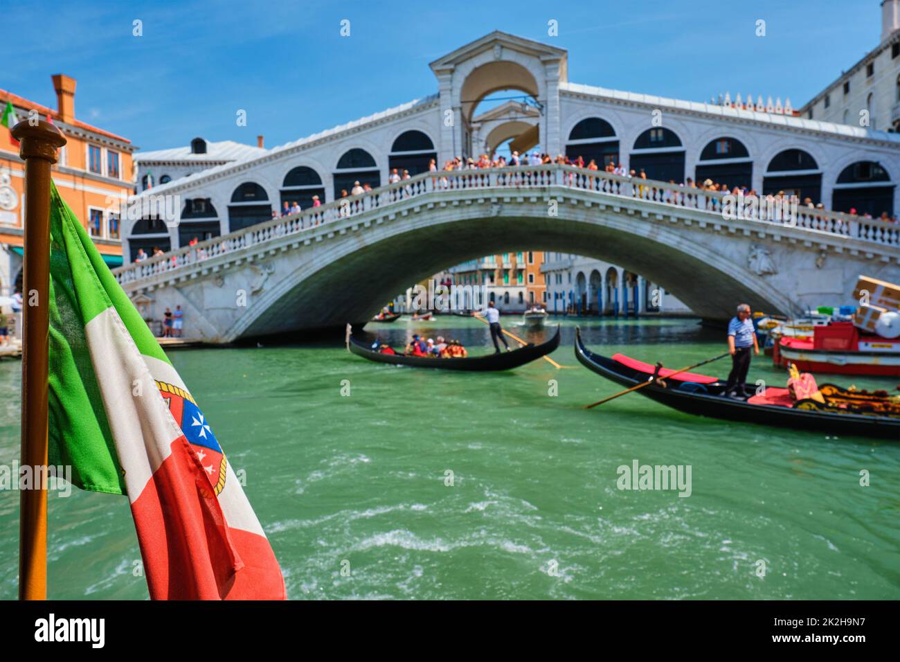 Italienische maritime Flagge mit Rialtobrücke mit Gondeln im bacground. Canal Grande, Venedig, Italien Stockfoto