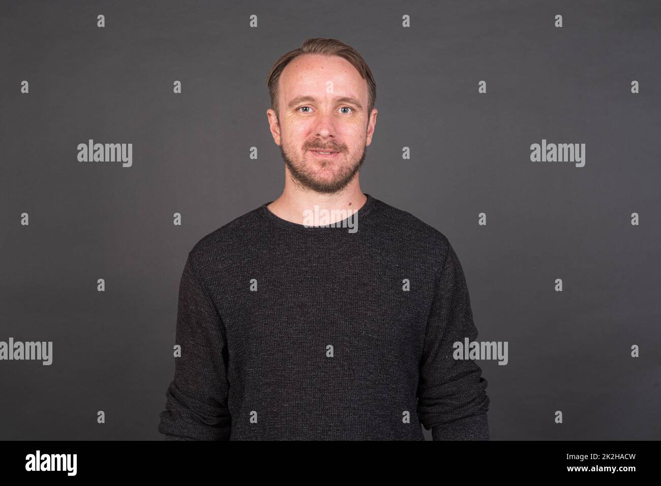 Studio-Porträt des blonden kaukasischen Mannes mit grauem Hemd Stockfoto