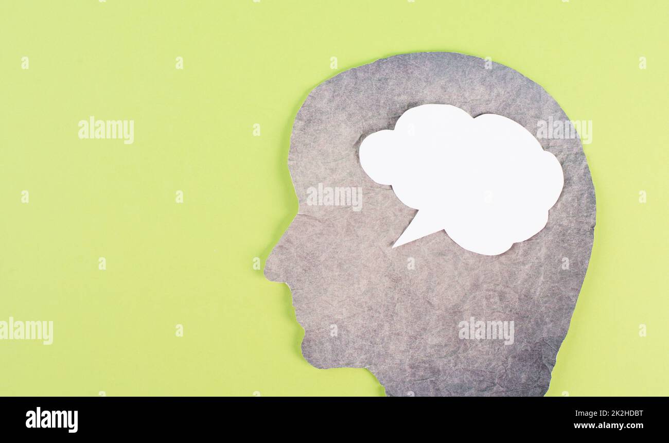 Silhouette eines Gesichts, Sprachblase in weißer Farbe, Kopierraum für Text, Kommunikation, Meinungsfreiheit, Gesprächsfreiheit, Grüner Hintergrund Stockfoto
