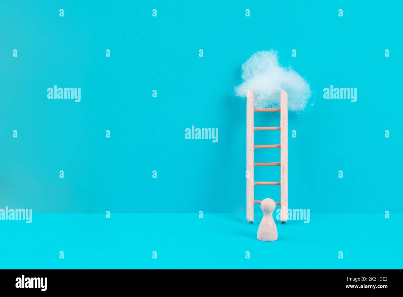 Der Mann steht neben einer Leiter, steigt in der Karriere auf, hat ein Ziel, sucht nach Ideen, Erfolgsstrategie, nimmt eine Herausforderung an, Geschäftskonzept Stockfoto