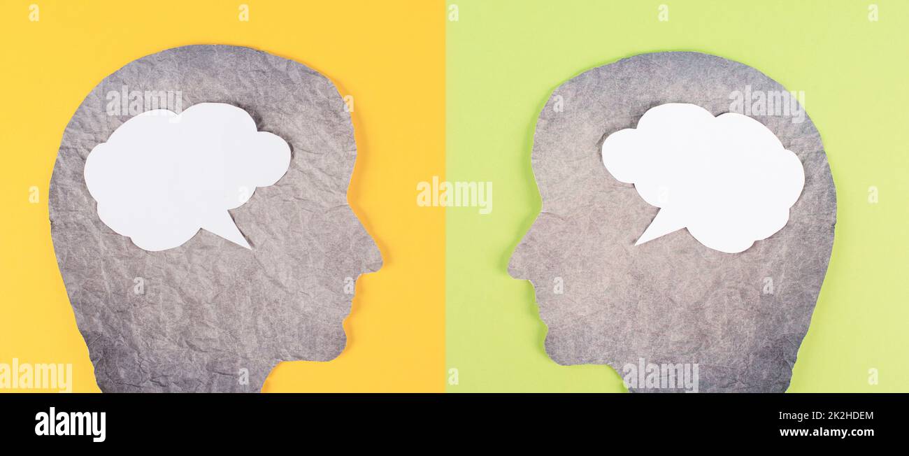 Silhouette aus zwei Gesichtern, Sprachblase in weißer Farbe, Kopierraum für Text, Kommunikation, Meinungen und Diskussionen, freie Meinungsäußerung, Gesprächspartner, grüner gelber Hintergrund Stockfoto