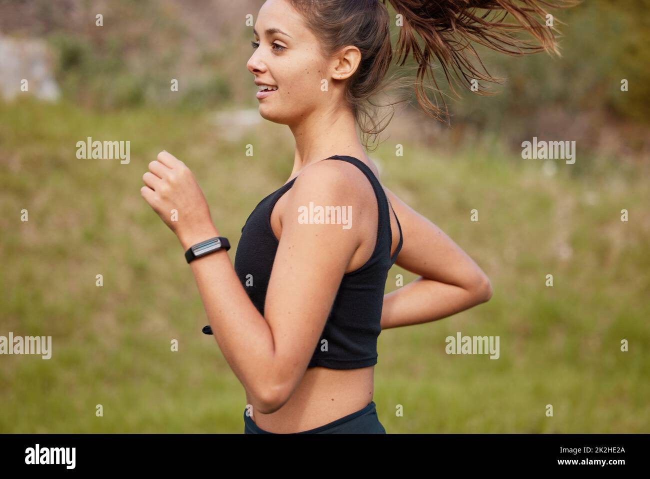 Sprint direkt in Richtung eines gesünderen Lebensstils. Aufnahme einer sportlichen jungen Frau, die im Freien läuft. Stockfoto