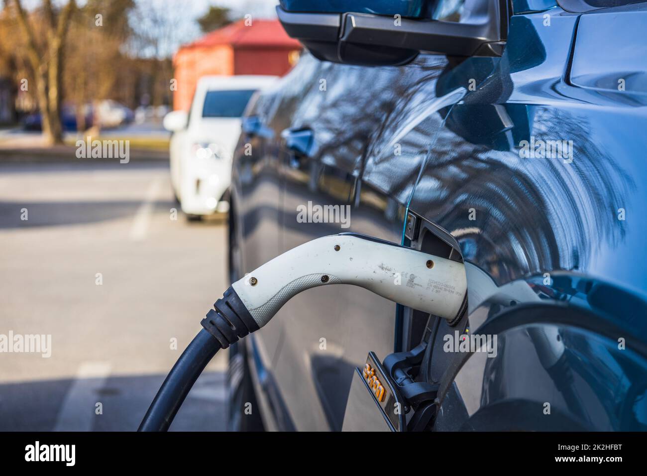 Elektrofahrzeug oder Elektroauto mit eingestecktem Netzkabel Stockfoto