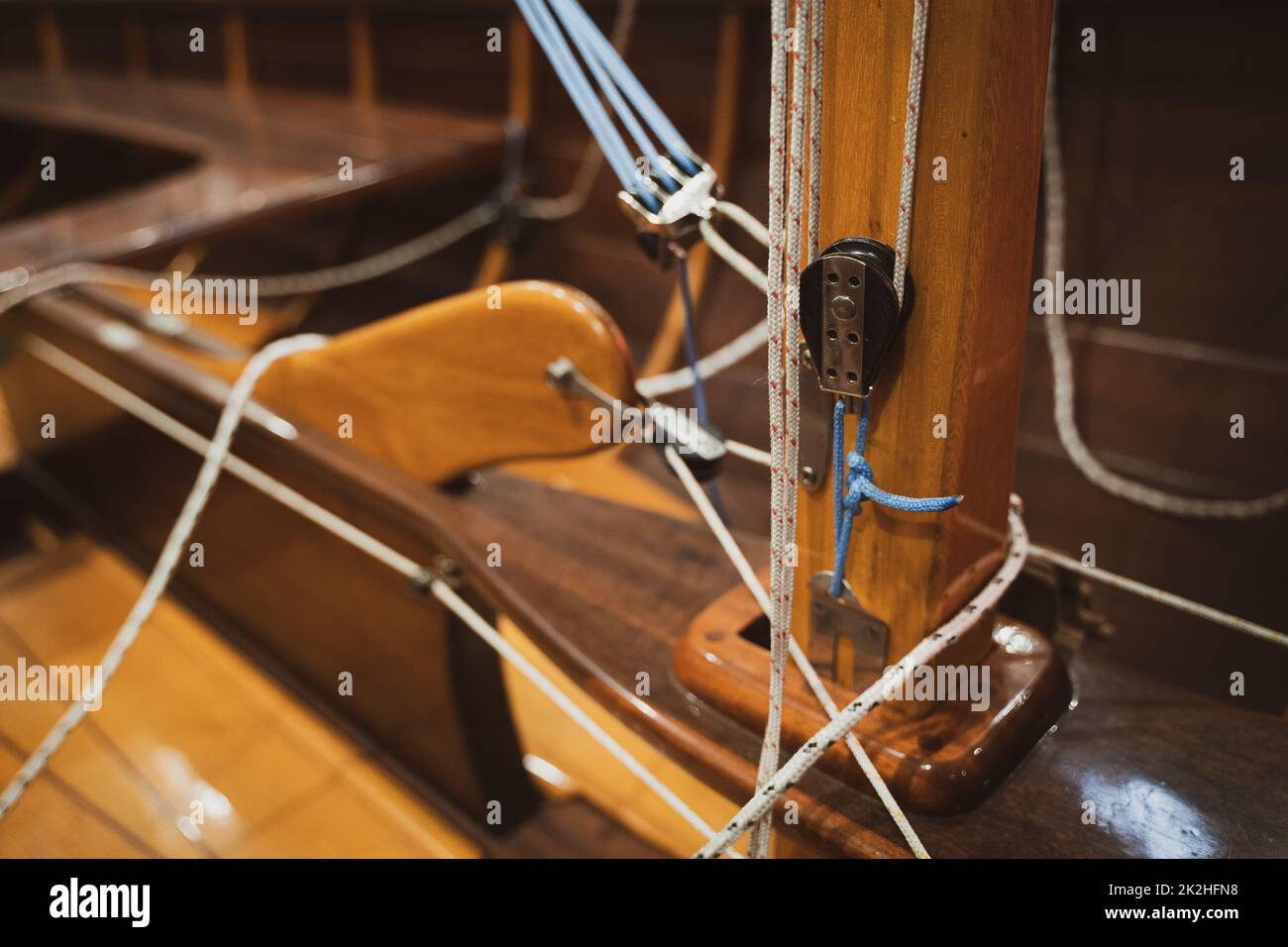 Nahaufnahme der Basis der Segelyacht Holzmast mit Seilen um ihn gebunden Stockfoto