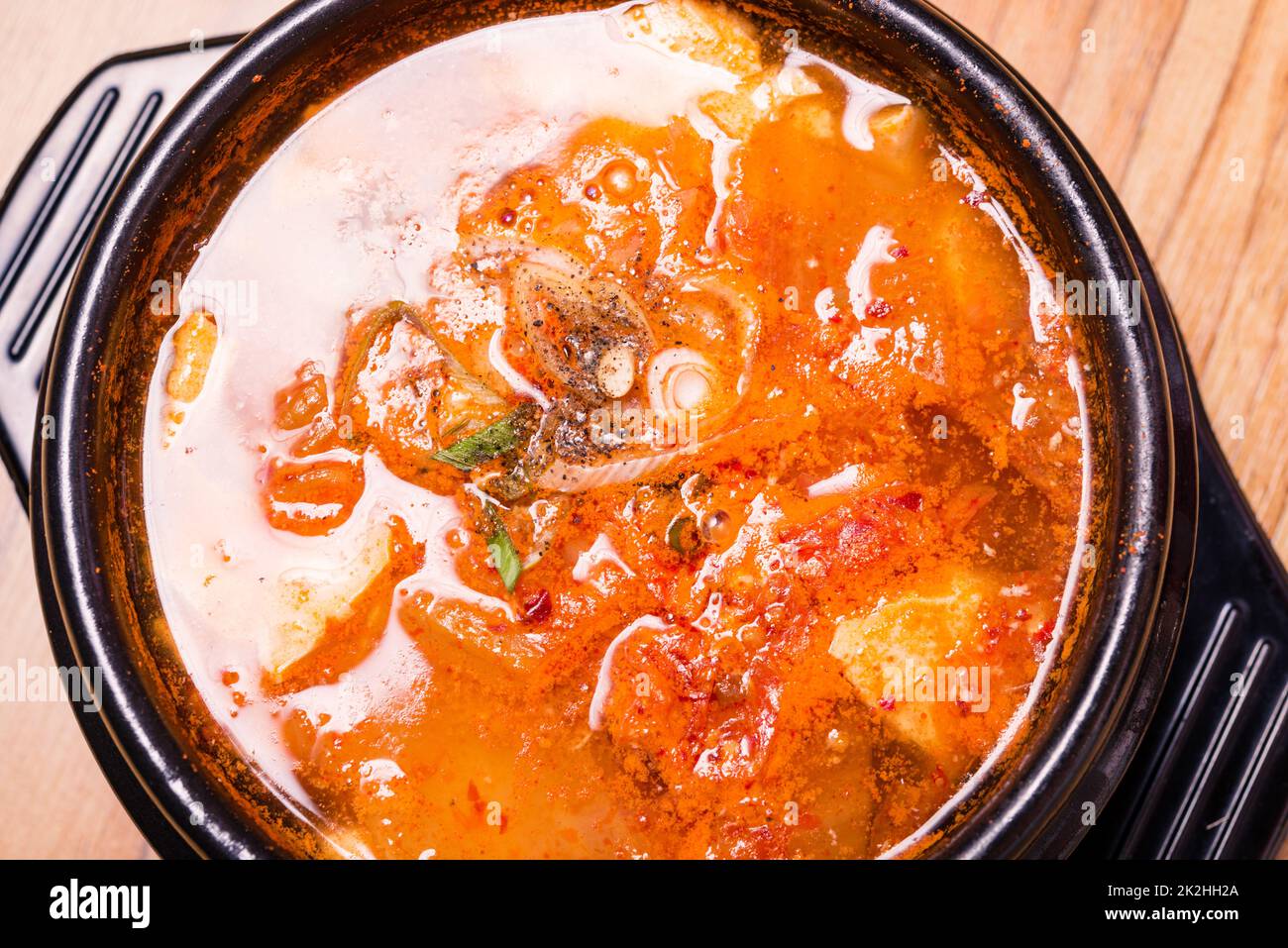 Kimchi-Suppe im heißen schwarzen Eisentopf, koreanische traditionelle ...