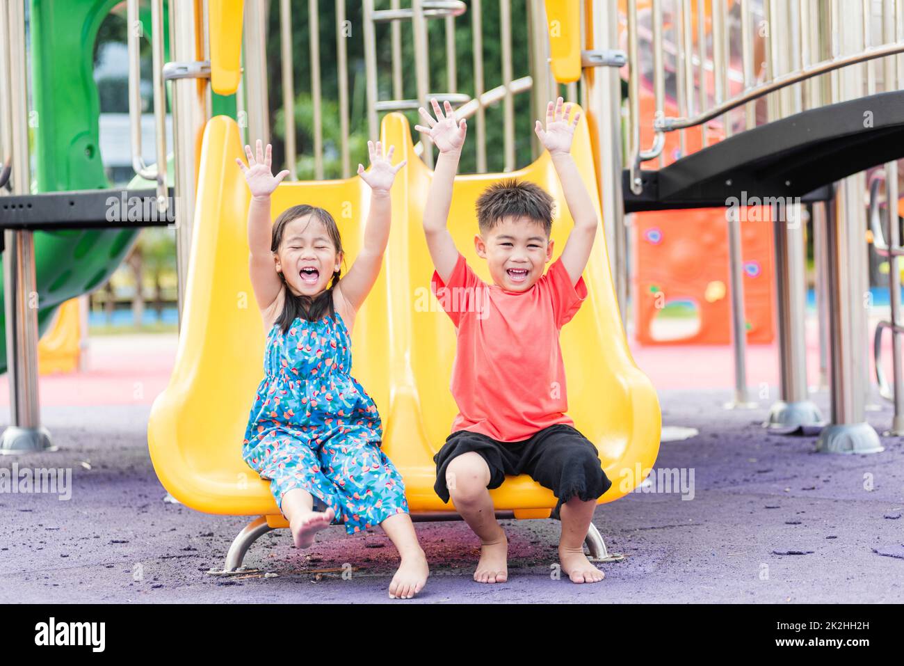 Asiatische Kind lächelnd spielen auf Slider Bar Spielzeug Outdoor Spielplatz Stockfoto