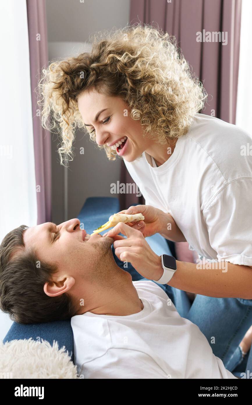 Glückliches Paar, das zu Hause leckere Pizza isst Stockfoto