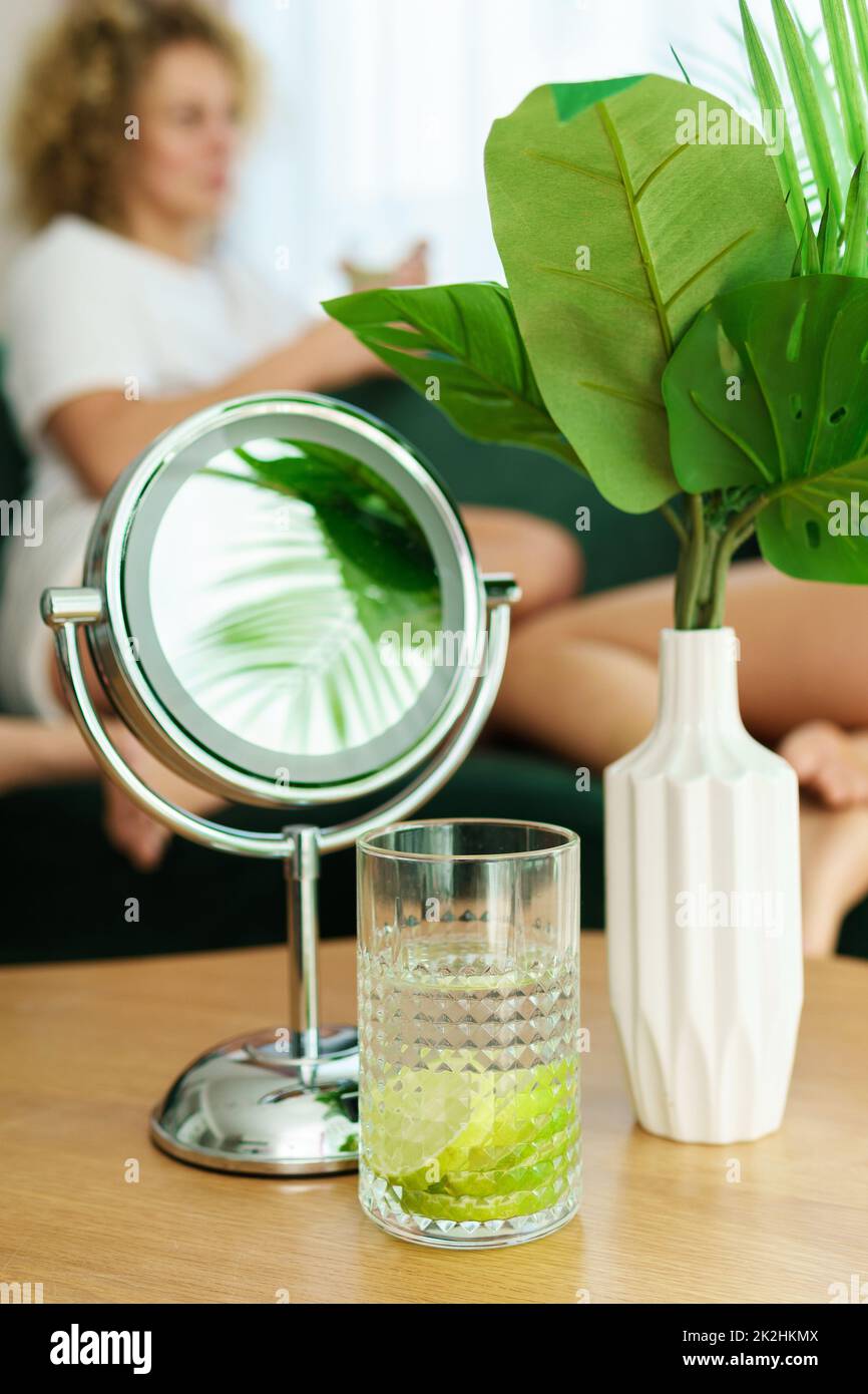 Runder Spiegel und ein Glas Entgiftungswasser auf dem Tisch Stockfoto