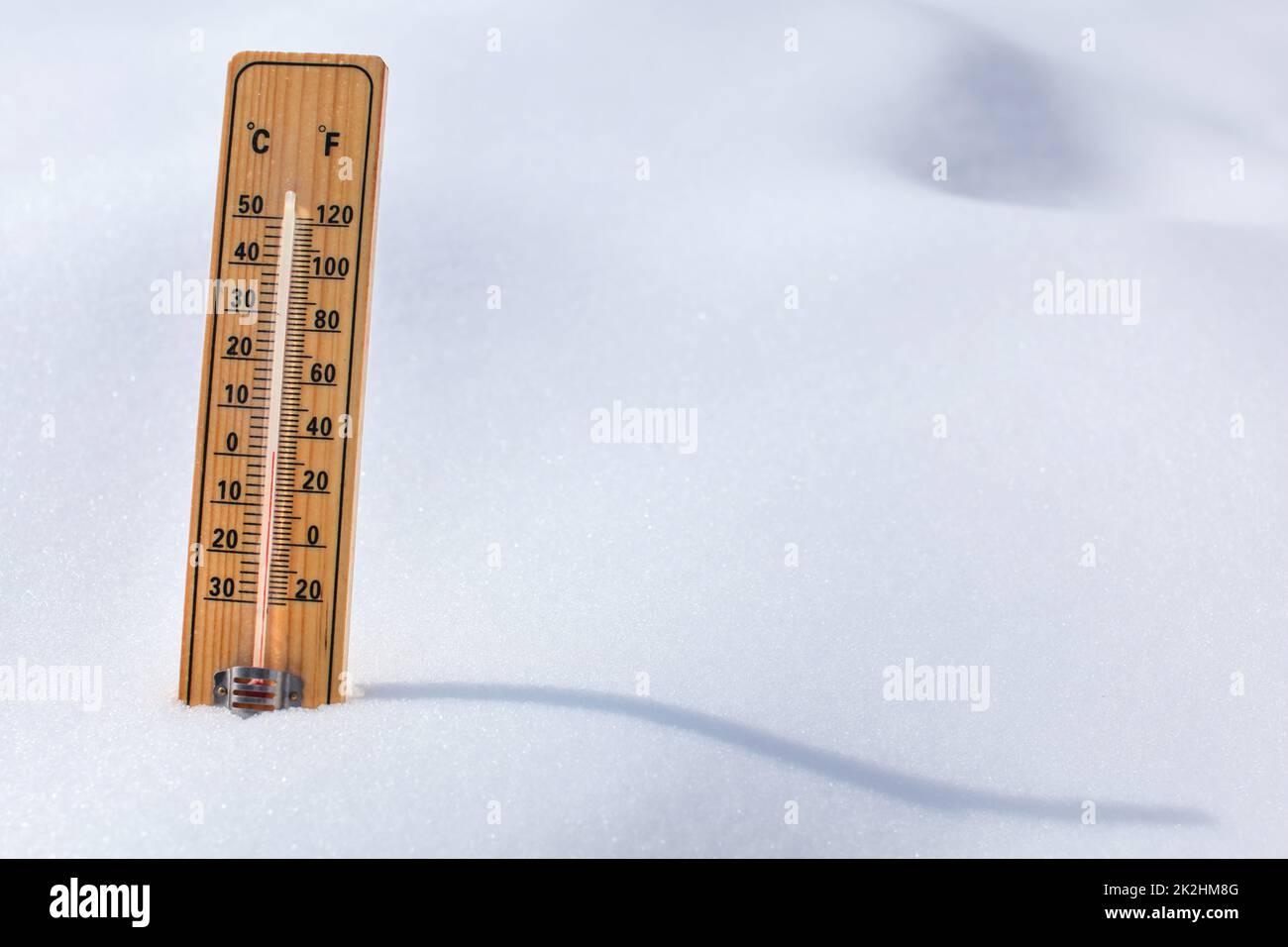 Holz- thermometer im Schnee, Sonne casting curvy Schatten, rote Spalte mit 0 Grad Celsius. Winter/Schnee kommen. Stockfoto