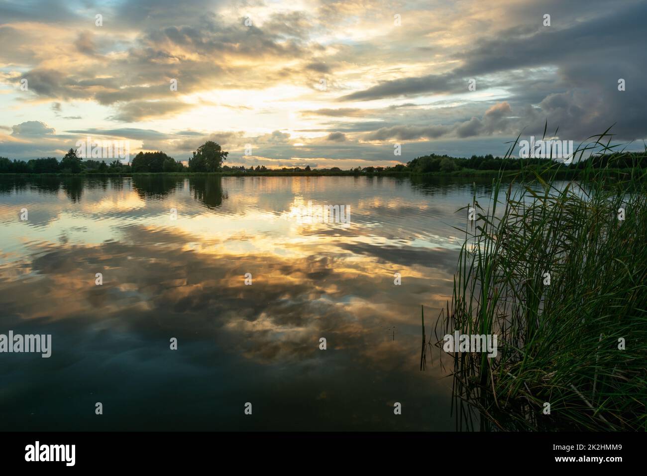 Abends Wolken über dem See mit Schilf Stockfoto
