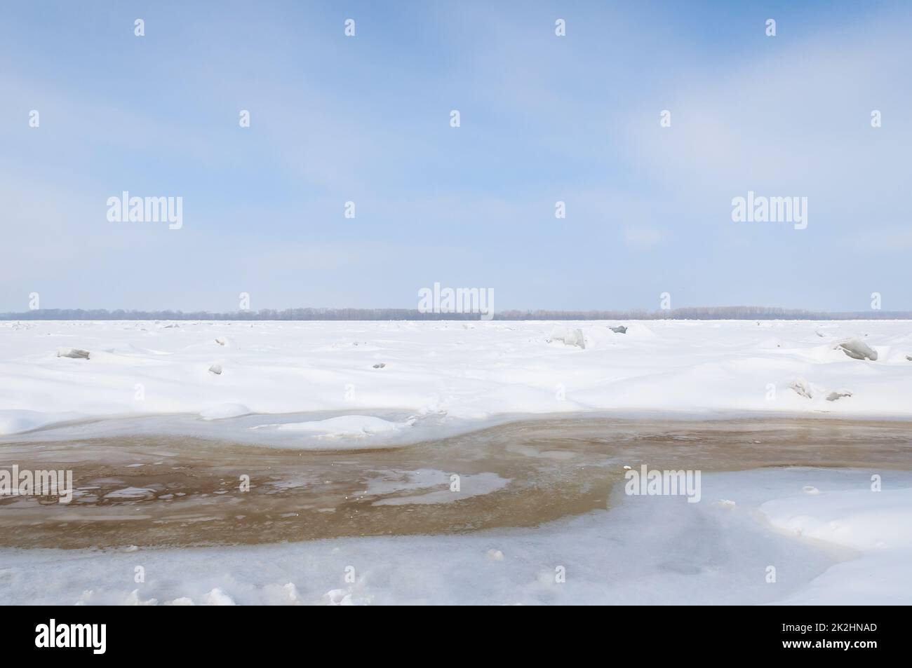 Atemberaubender Blick auf den gefrorenen Fluss bedeckt mit Eisstücken und weißem Frostschnee. Verschneite Wüste. Stockfoto