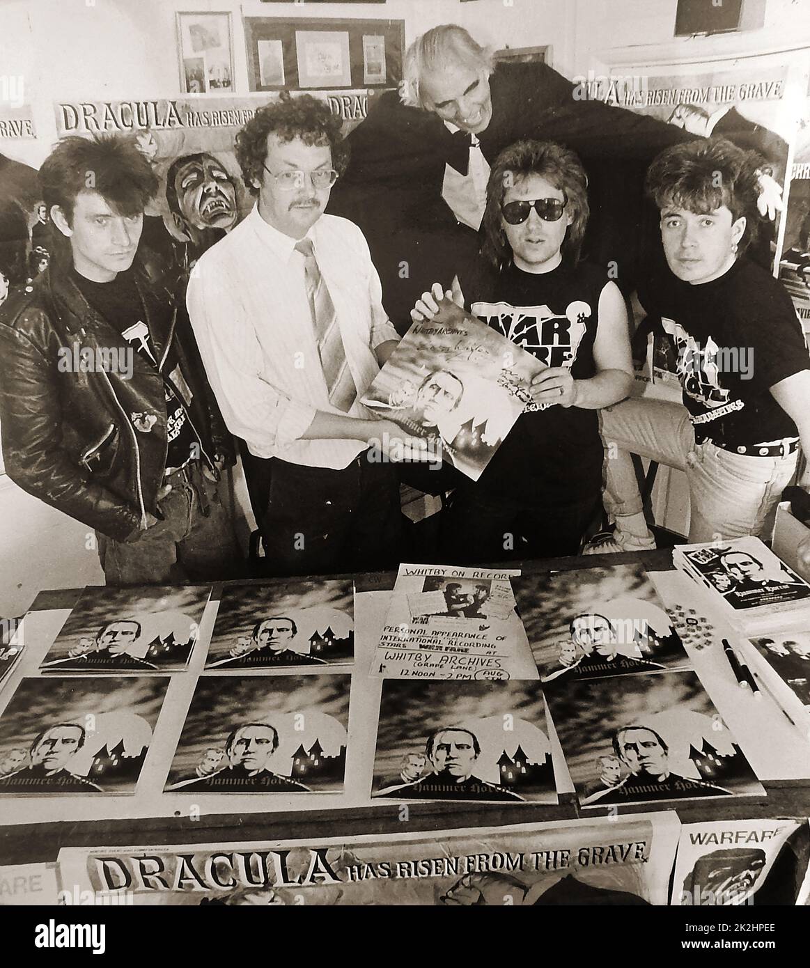 WARFARE Rockband im August 1990. Ein Foto, das bei der Veröffentlichung ihres HAMMER-HORROR-Albums aufgenommen wurde. Evo (Paul Evans, Mitte rechts) übergibt dem ehemaligen Whitby Archives Heritage Center , Regisseur Colin Waters, in der Grape Lane, in Anwesenheit der anderen Bandmitglieder und Rex (Dracula) Greenwood ein signiertes Exemplar des neuen Albums. Stockfoto