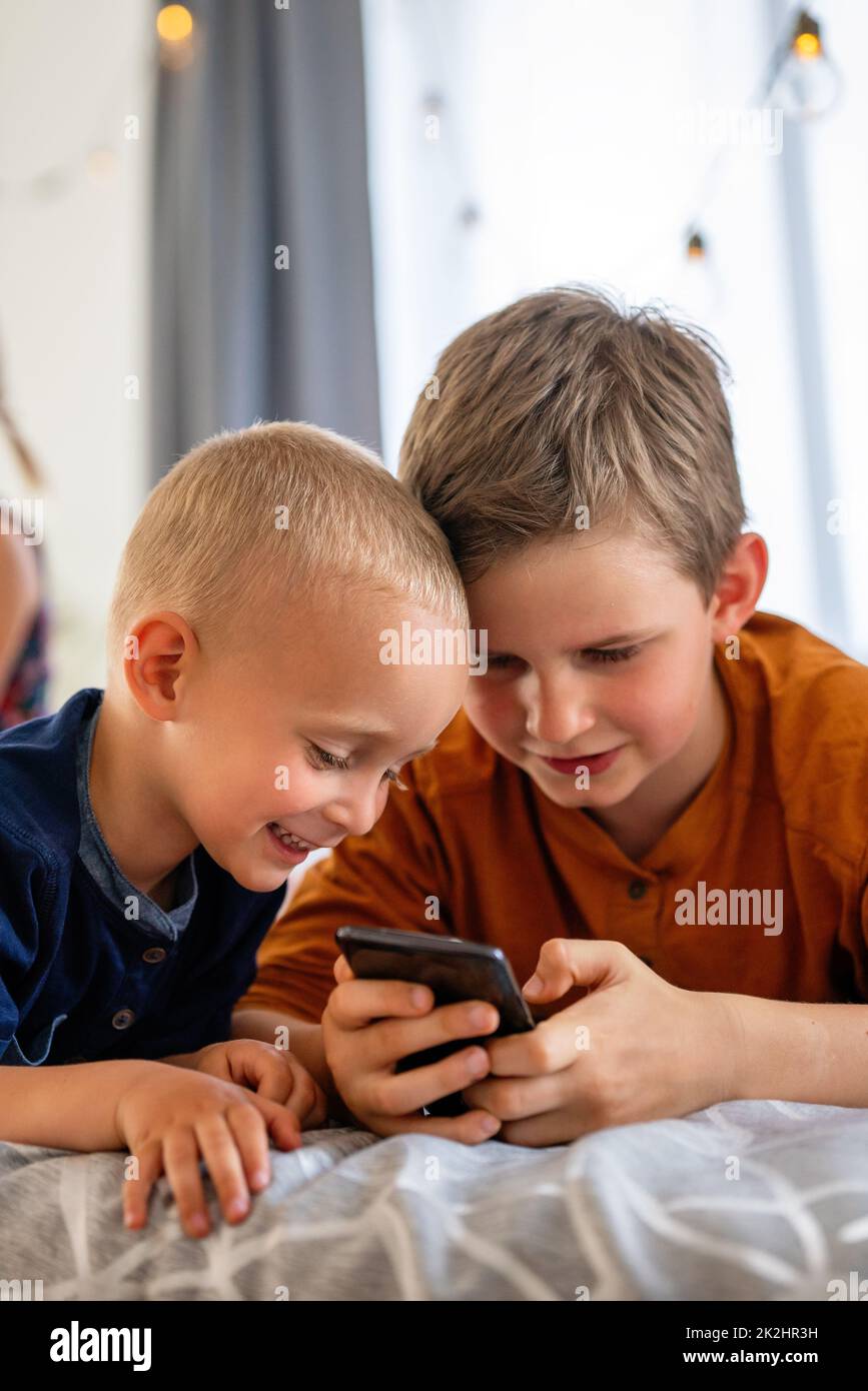 Portrait von glücklichen Kindern, die digitale Geräte nutzen und gemeinsam Spaß haben. Stockfoto