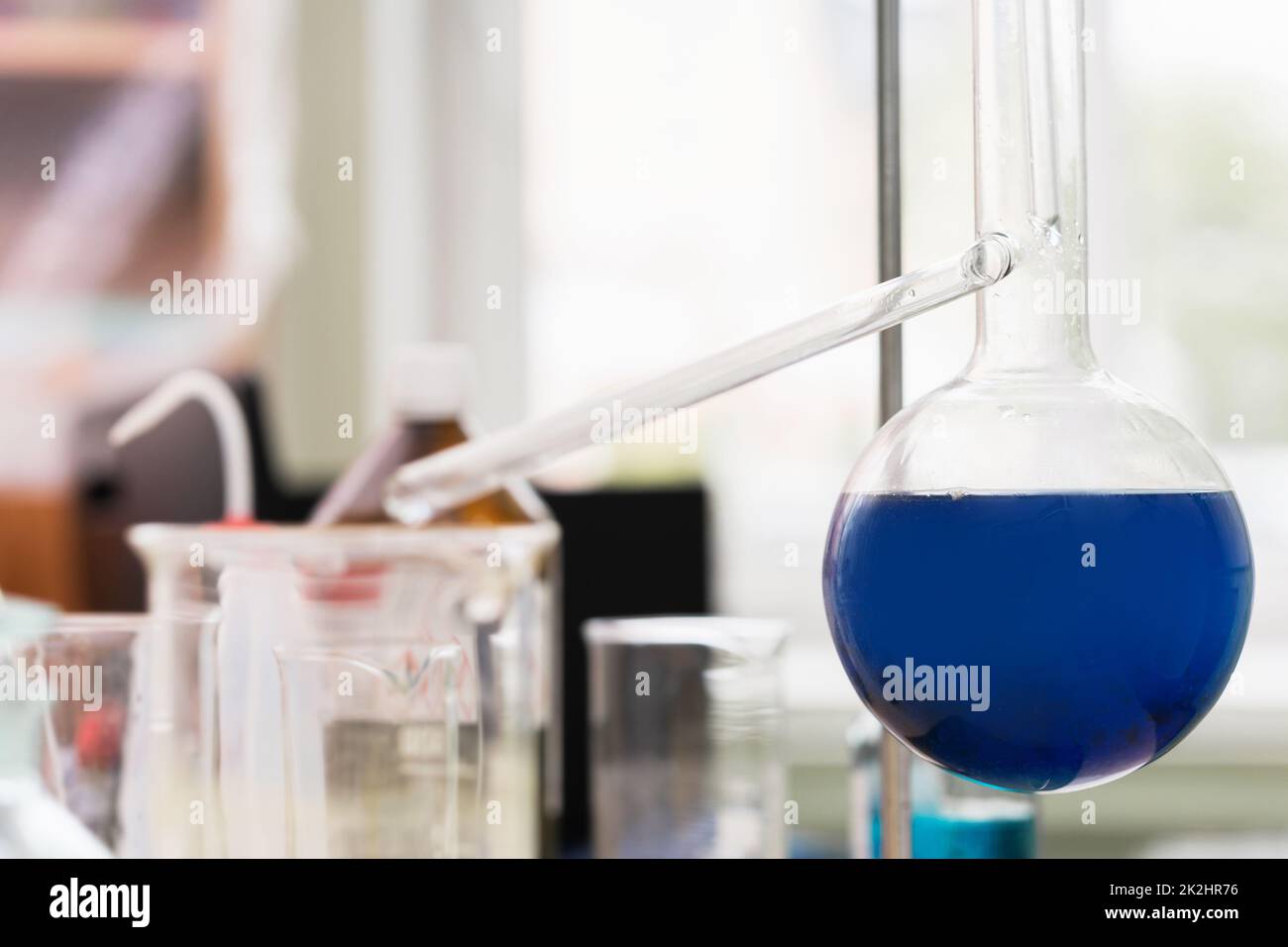 Retortionskolben, gefüllt mit einer blauen Substanz in einem Labor Stockfoto