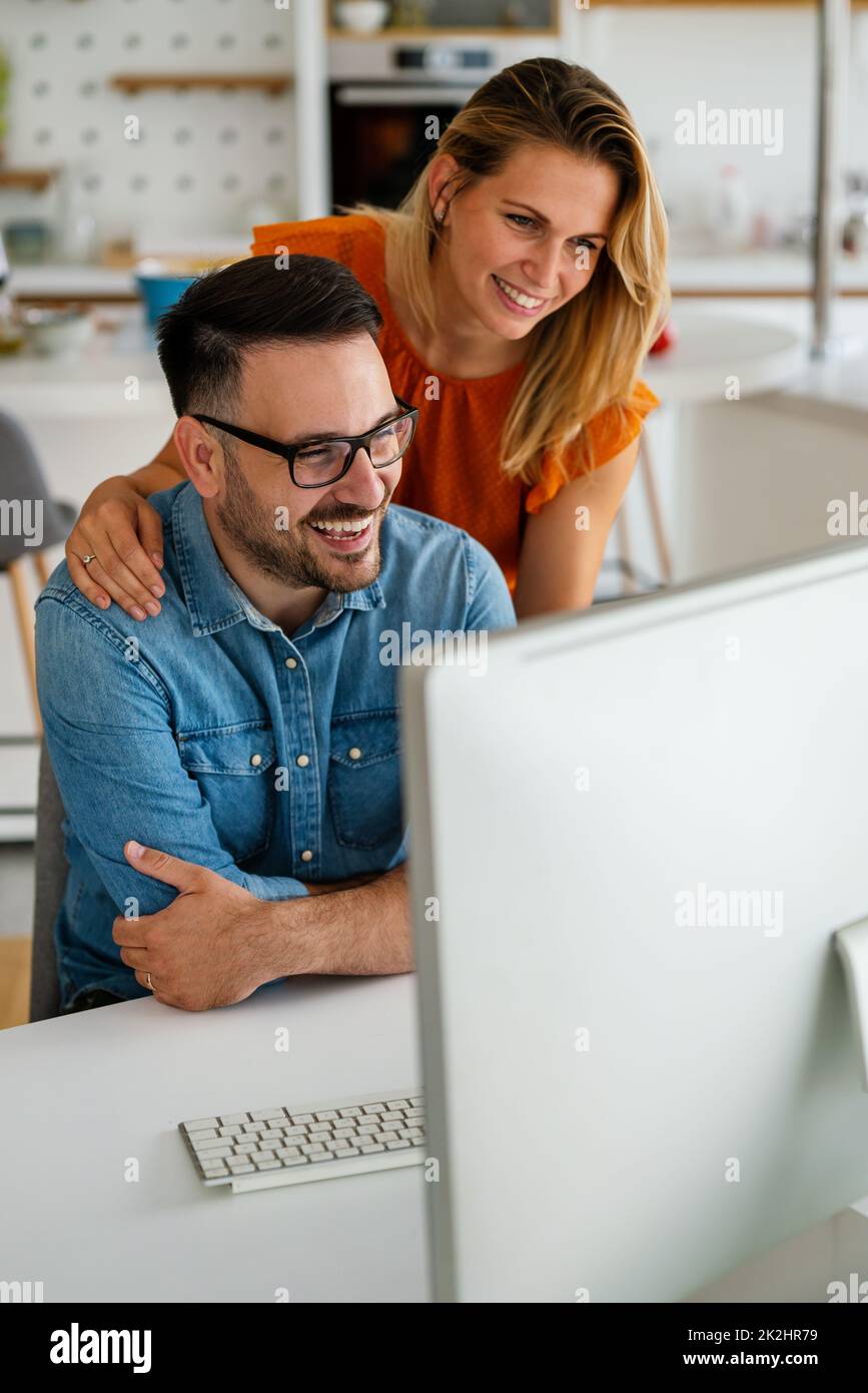 Glückliches Paar, das gemeinsam Geschäfte macht und in einem kleinen Büro arbeitet Stockfoto