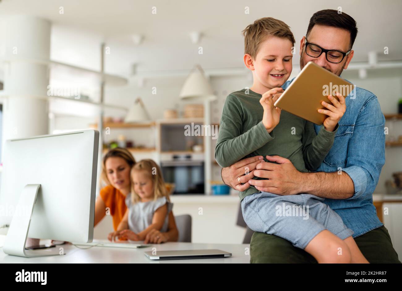 Online-Bildungskonzept der Produktfamilie der Gerätetechnologie. Glückliche Familie mit digitalen Geräten zu Hause. Stockfoto