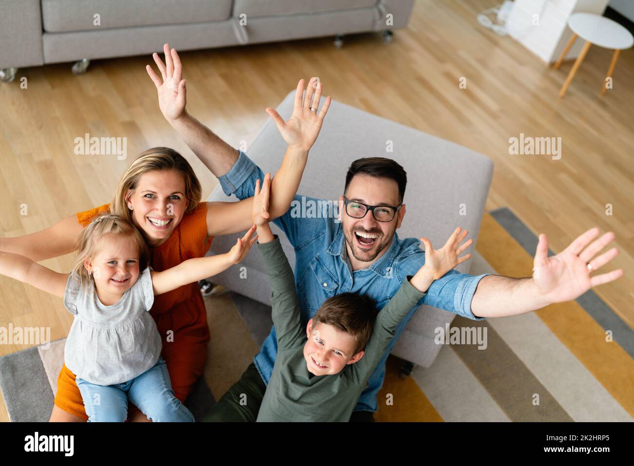 Glückliche Familie, die Spaß zu Hause hat. Eltern spielen lächelnd mit Kindern zusammen. Stockfoto