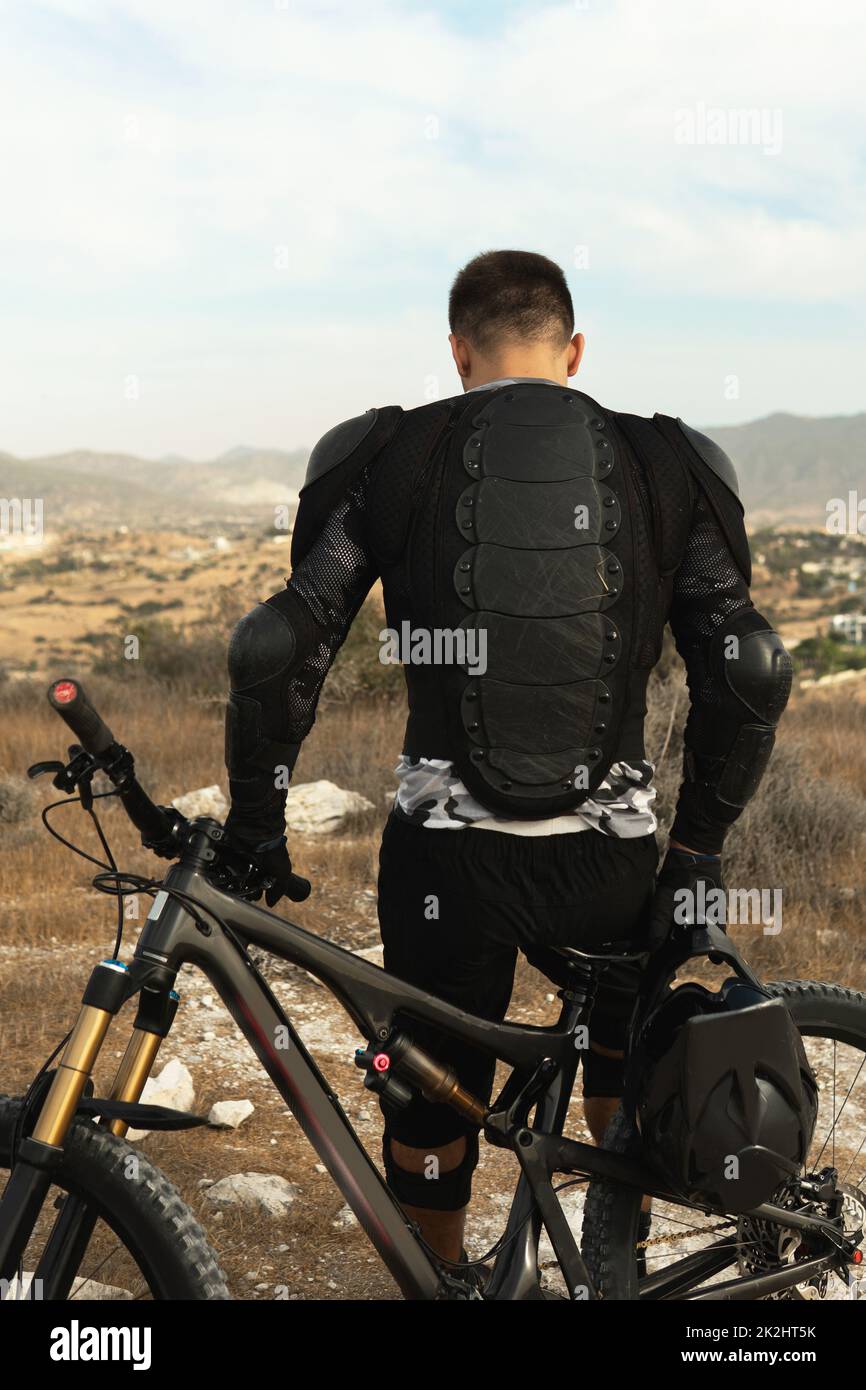 Downhillfahrer voll ausgestattet mit Schutzausrüstung und seinem Fahrrad Stockfoto