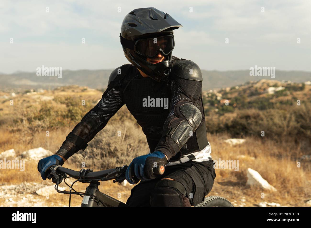 Downhillfahrer voll ausgestattet mit Schutzausrüstung auf seinem Fahrrad fahren Stockfoto