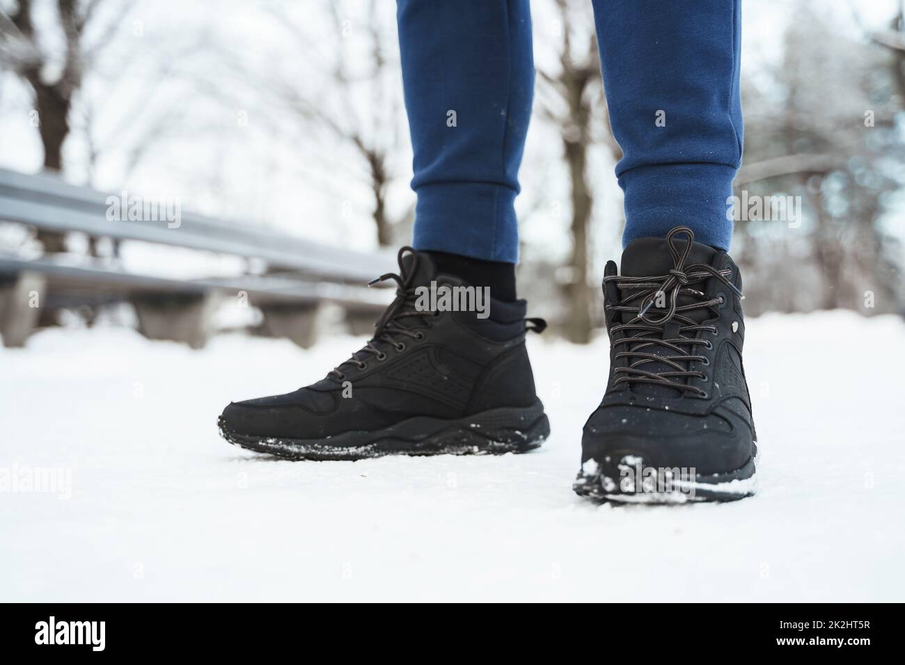 Mann in schwarzen Turnschuhen im Winter City Park Stockfoto