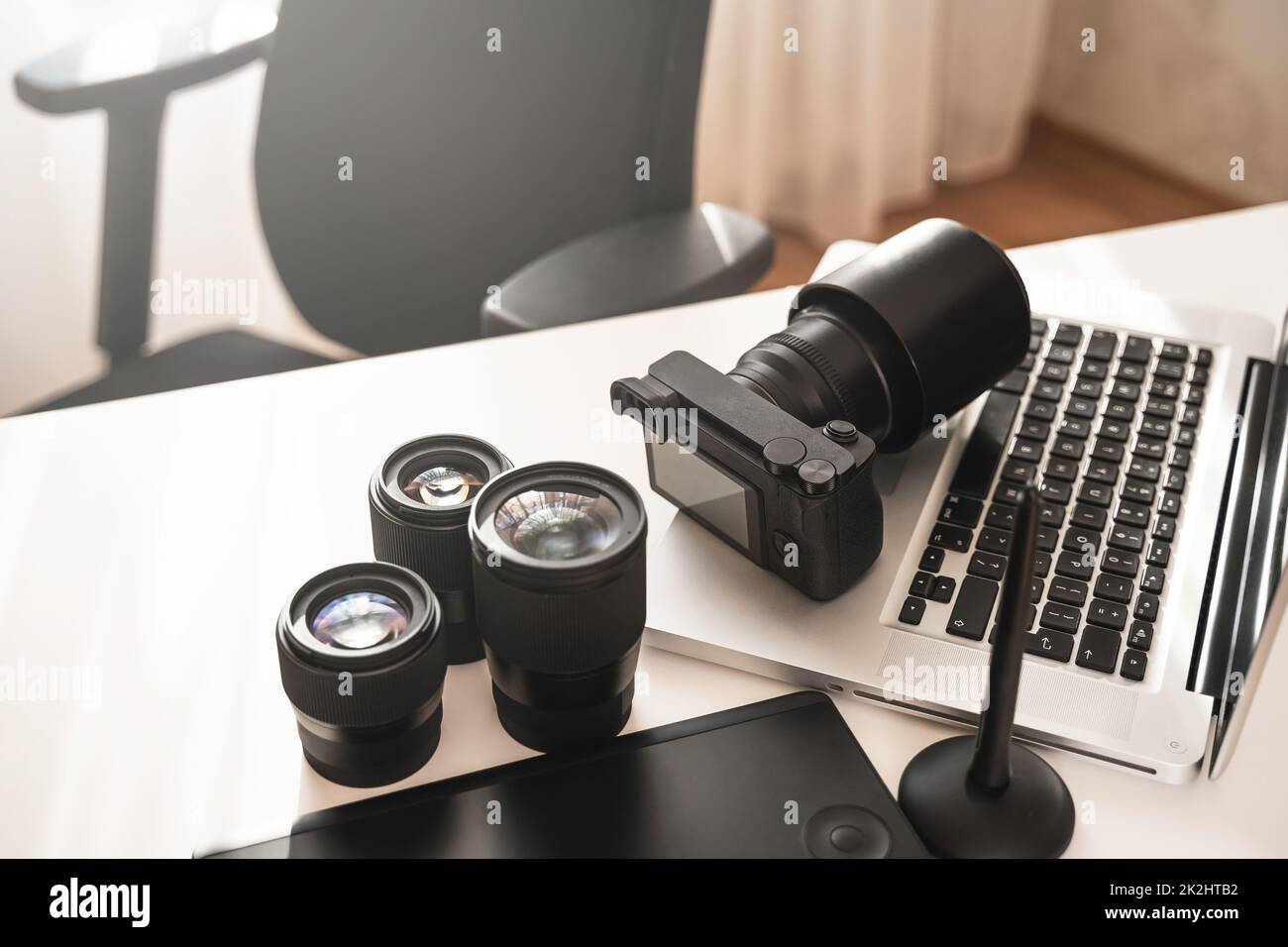 Arbeitsplatz mit moderner Ausrüstung für die Fotografie. Spiegellose Kamera und Objektive mit Festbrennweite. Stockfoto