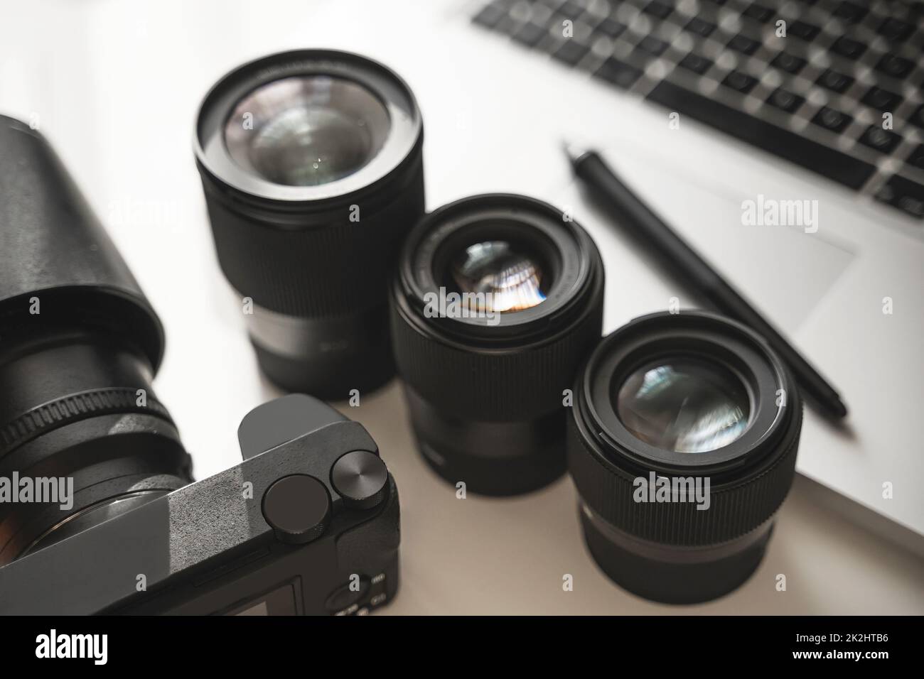 Arbeitsplatz mit moderner Ausrüstung für die Fotografie. Spiegellose Kamera und Objektive mit Festbrennweite. Stockfoto