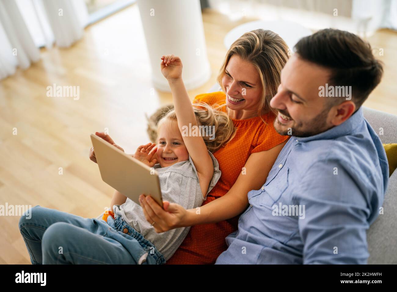 Glückliche Familie, die gemeinsam mit digitalen Geräten zu Hause Zeit verbringt. Technologie Menschen Spaß Konzept. Stockfoto