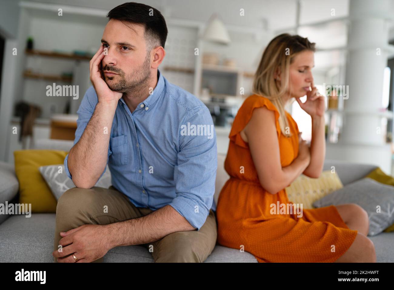 Traurige, nachdenkliche Paare, die an Beziehungsprobleme denken, die auf dem Sofa sitzen, Konflikte in der Ehe. Stockfoto