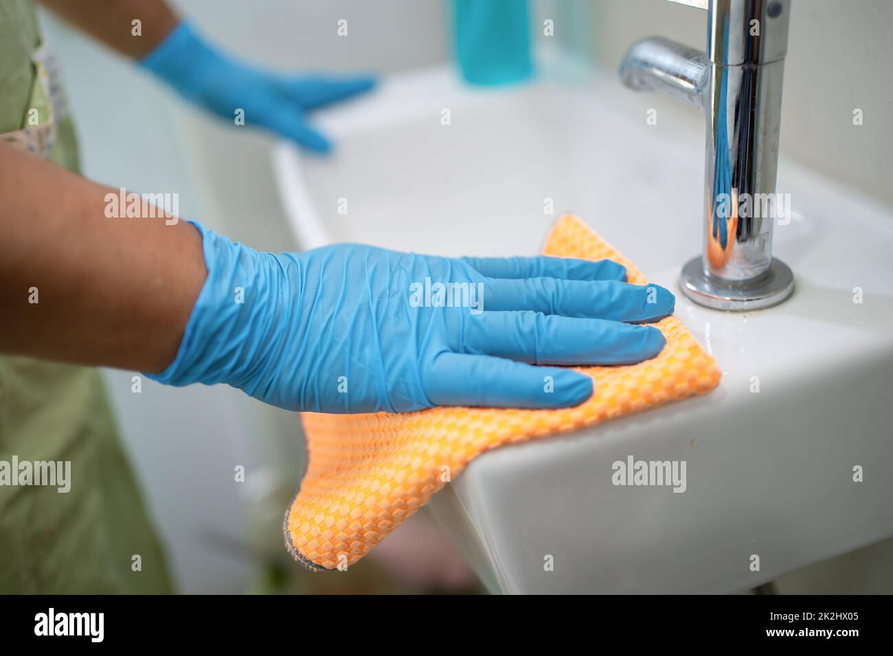 Zimmermädchen waschen und schrubben Waschbecken in der Toilette zu Hause. Stockfoto