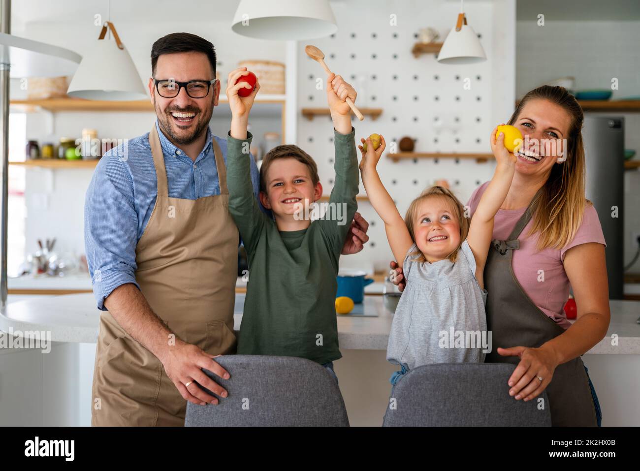 Glückliche Familie mit Kindern, die gemeinsam in der Küche gesunde Lebensmittel zubereiten Stockfoto