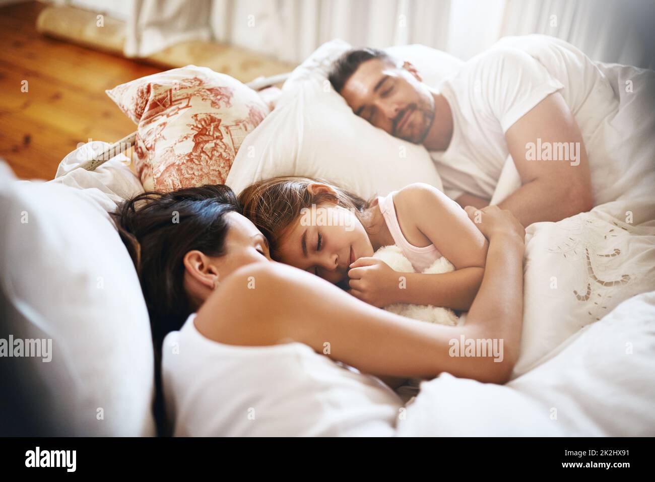 Schlafen Sie friedlich in einem Bett. Aufnahme einer Familie, die zu Hause im Bett schläft. Stockfoto
