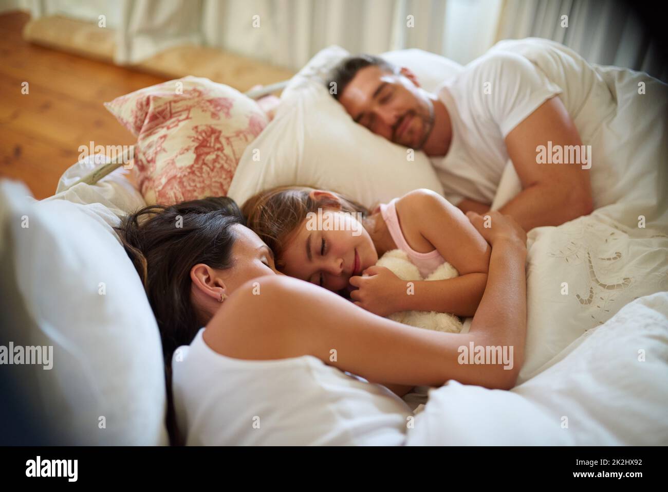 Familie kuscheln sich Zeit. Aufnahme einer Familie, die zu Hause im Bett schläft. Stockfoto