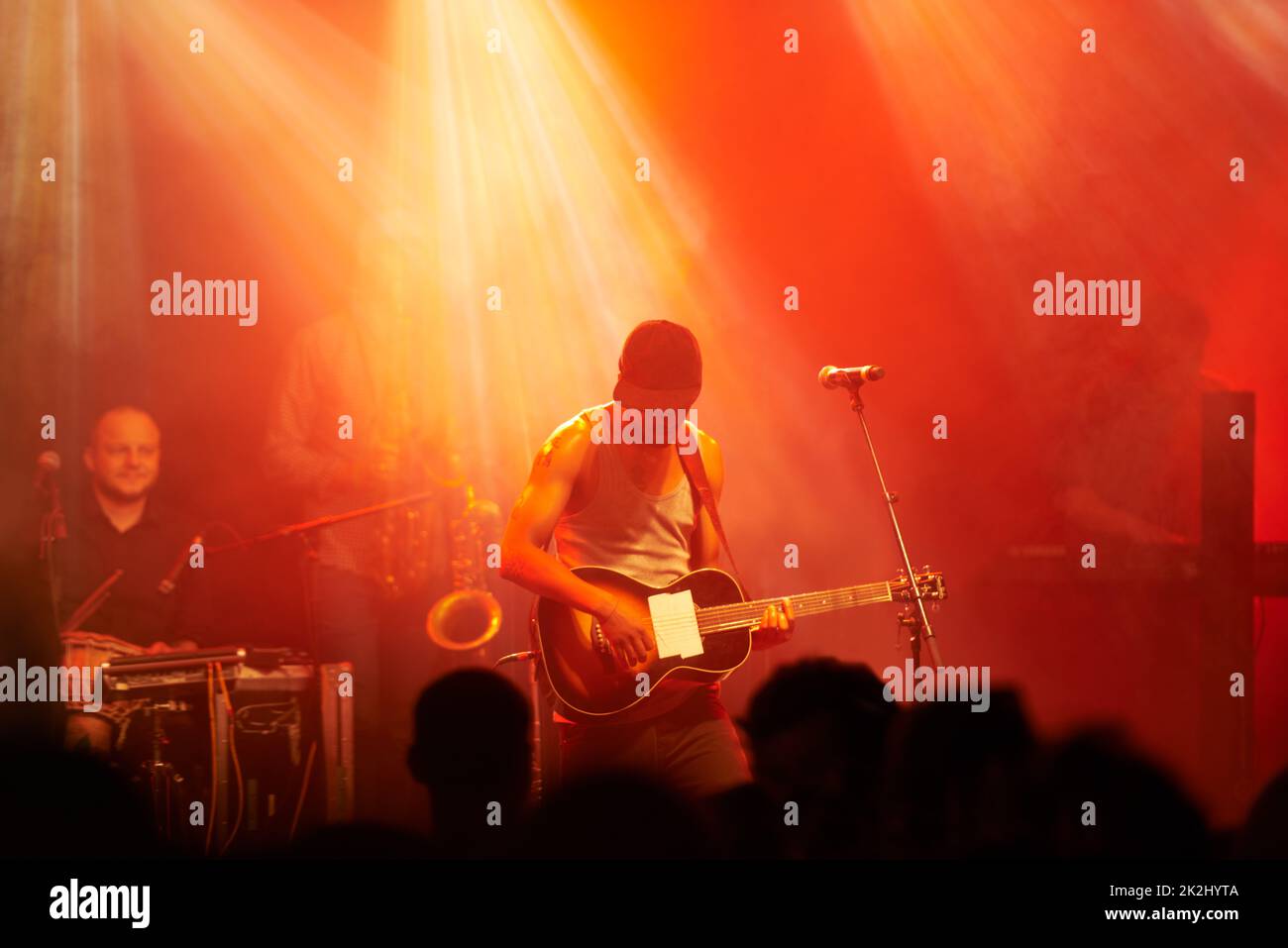 Den Fans das Solo geben. Aufnahme eines Gitarristen, der bei einem Konzert auf der Bühne spielt. Stockfoto
