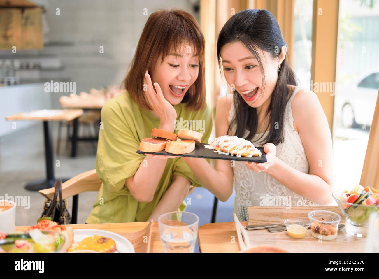 Glückliche Freundinnen, die gemeinsam im Restaurant zu Mittag essen Stockfoto
