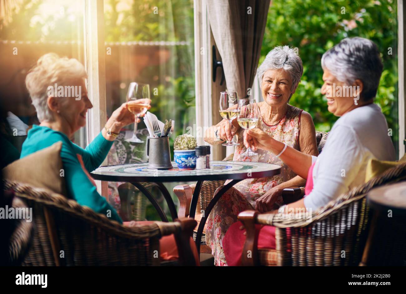 Es ist ein Fest. Zugeschnittene Aufnahme einer Gruppe älterer Freundinnen, die während eines Mittagessens toasten. Stockfoto