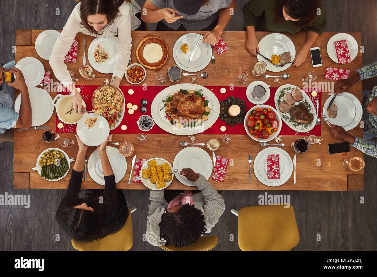 Essen macht das Zusammenkommen einfach. Aufnahme einer Gruppe von Leuten, die zusammen an einem Esstisch sitzen und bereit zum Essen sind. Stockfoto